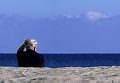 Anziana donna di paese al mare. Marina di Orosei, la spiaggia presso la foce del Cedrino. Orosei (Nuoro) Sardegna. Italia.